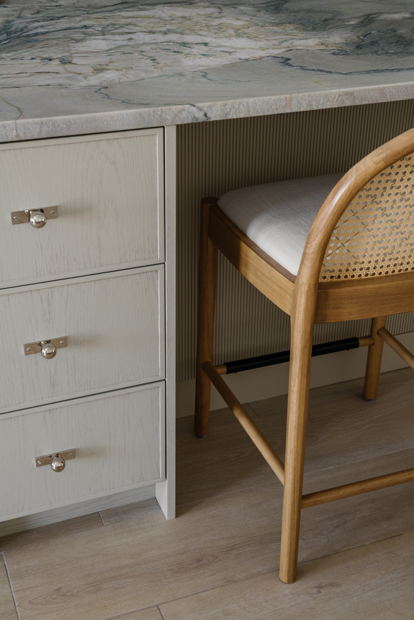 Details at kitchen island featuring polished nickel knobs with rectangular backplates, quartzite countertops and slatted millwork panels