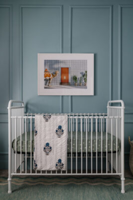 Blue Nursery by Jenilee Greene Design with white metal crib, block print throw and framed gray malin art above crib.