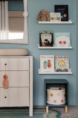 Blue Nursery by Jenilee Greene Design with mirror, changing table and wall mounted bookshelves