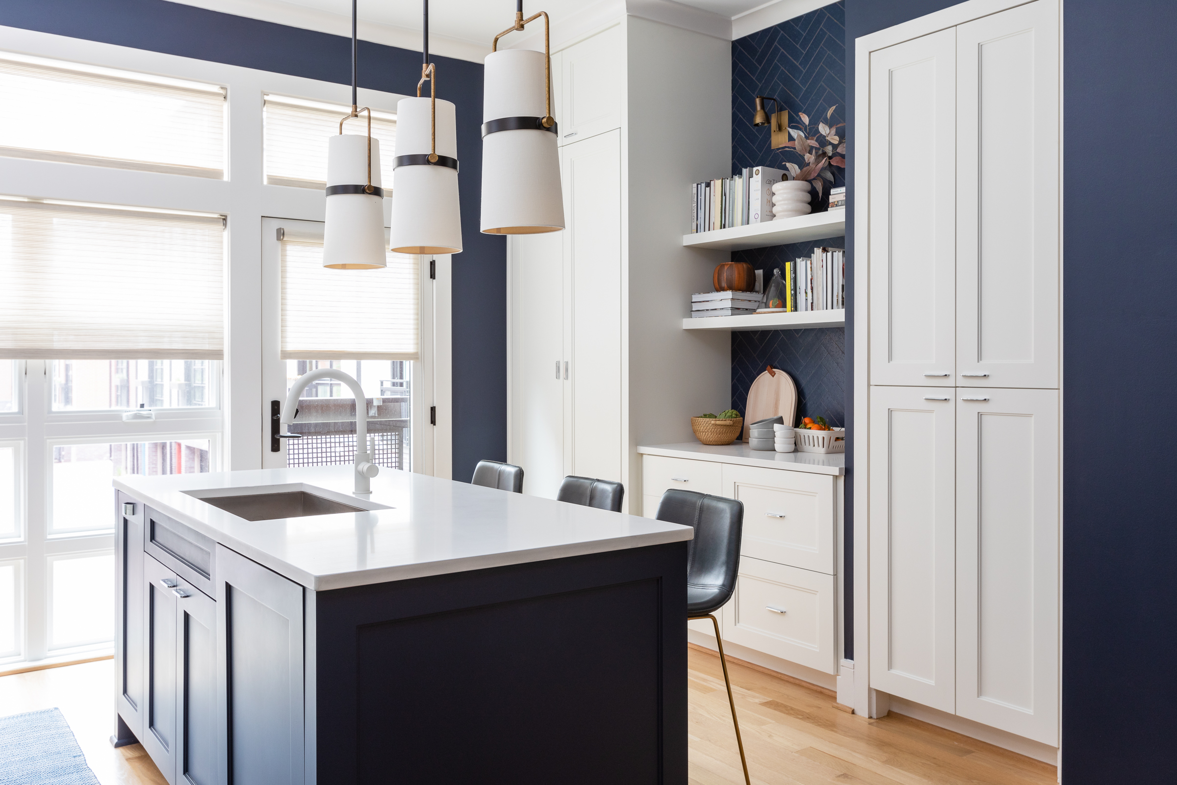 Coffee station statement kitchen pendants open shelving woven shades library feel cookbook storage brass sconces herringbone brick tile texture warmth