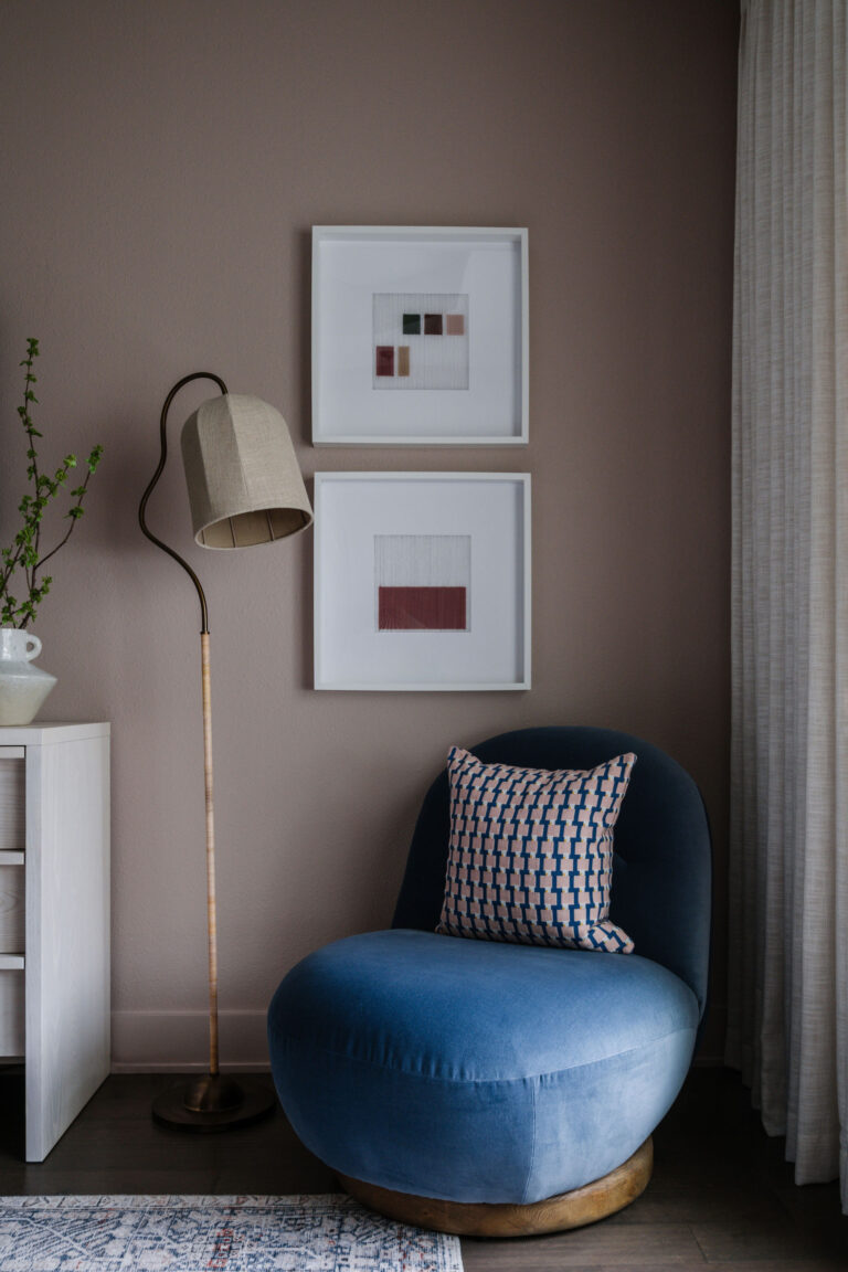 blue velvet chair vignette with graphic pillow and statement floor lamp